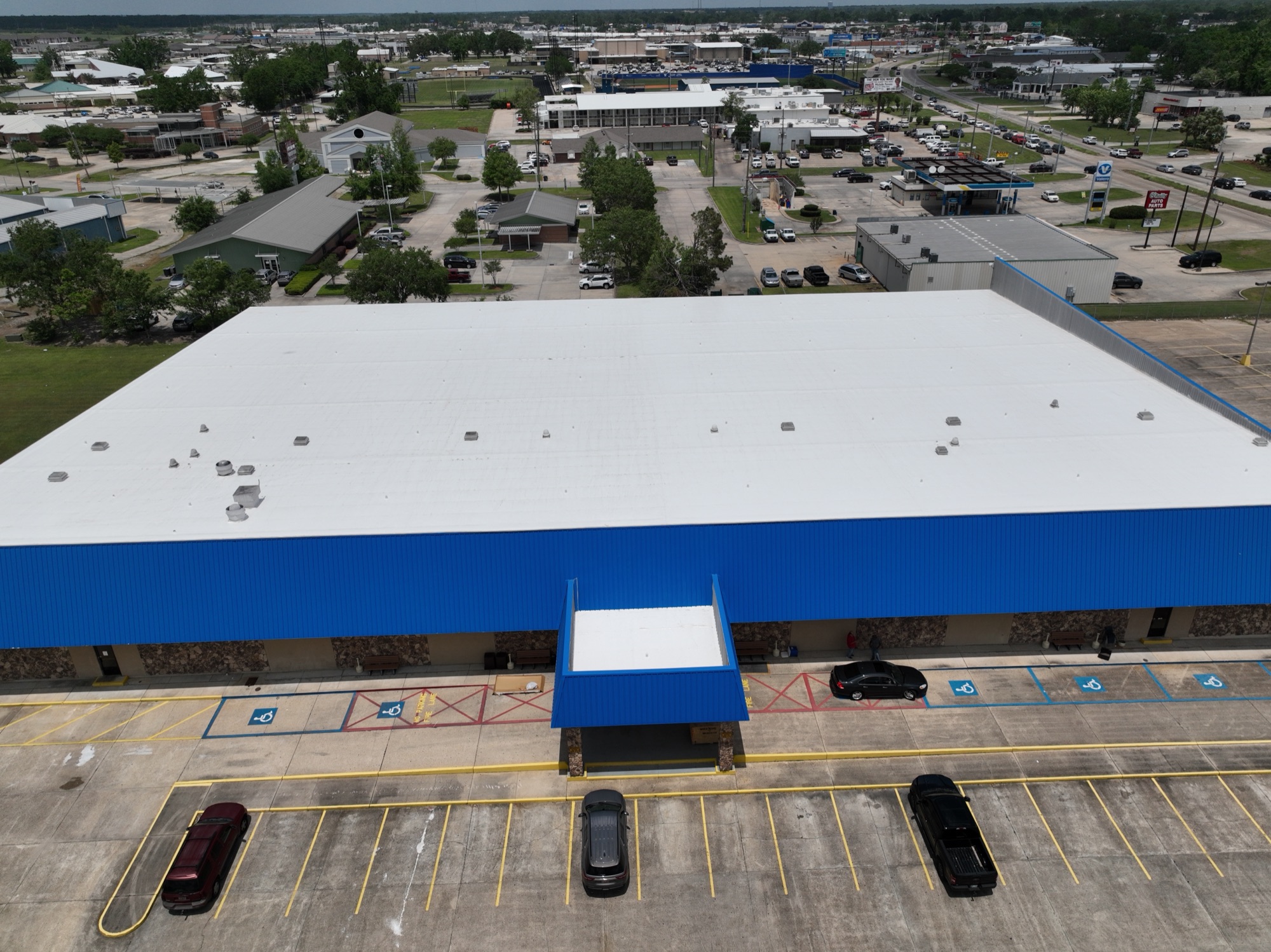 Front view of a 30,000+ sq ft retail building in Louisiana with newly installed white TPO roof after Hurricane Ida damage replacement.