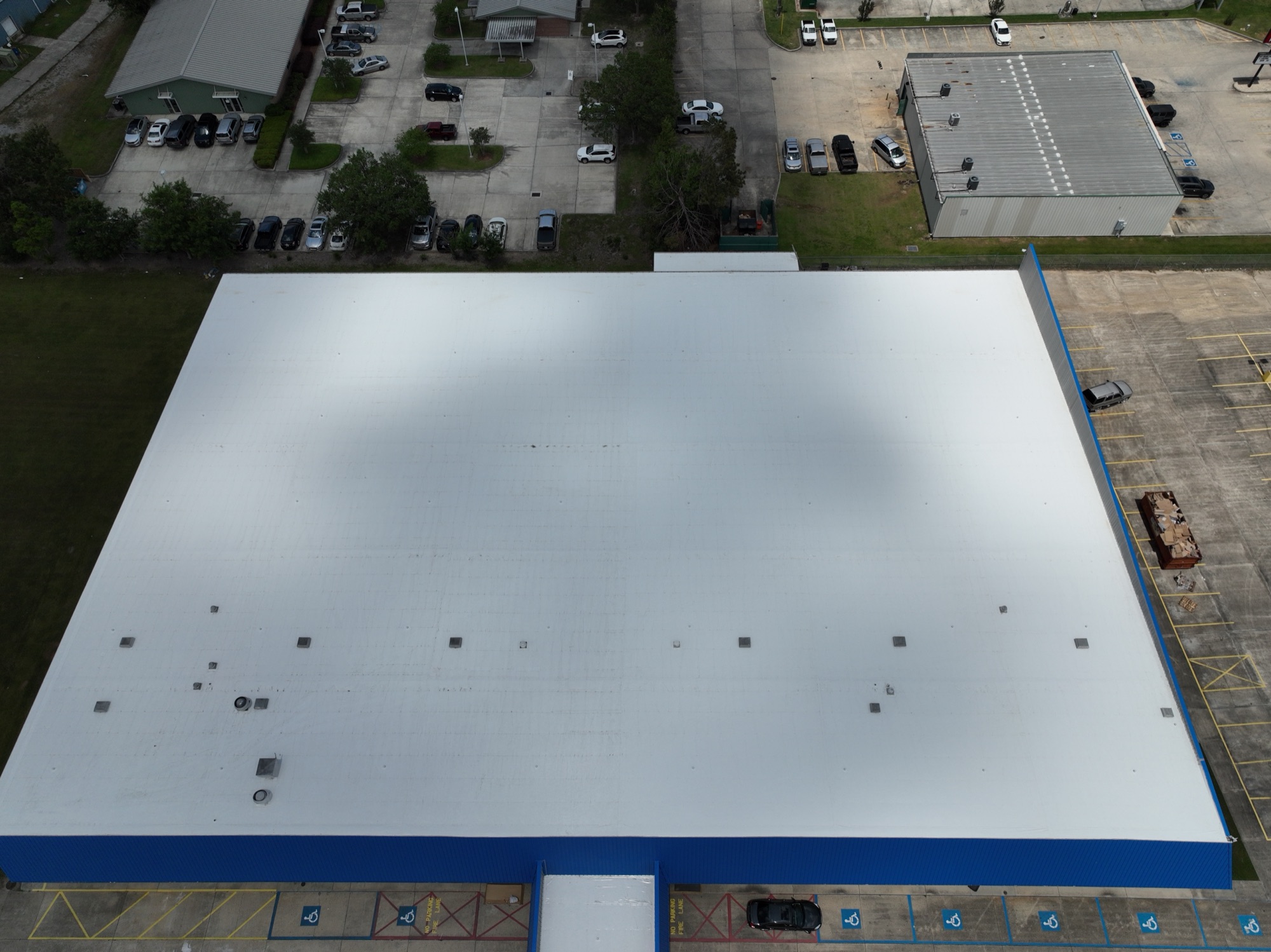 Aerial top-down view of a large commercial TPO roof replacement in Louisiana, showing the full scale of the post-Hurricane Ida restoration.
